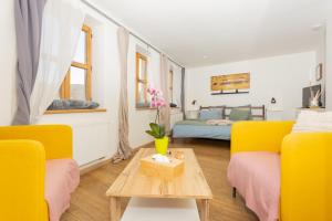 a living room with two yellow chairs and a table at Penzion Quest in Loket