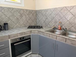 a kitchen with a sink and a stove at Escapade Océane in Quartier du Fond Fleuri +8 photos