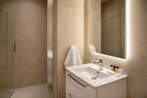 a bathroom with a sink and a mirror at L Residences & Suites in Larnaca +50 photos