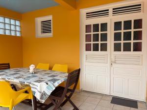 a dining room with a table and yellow walls at Escapade Océane in Quartier du Fond Fleuri