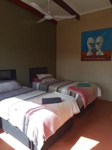 a bedroom with two beds and a ceiling fan at Karoo Saloon in Barrydale +20 photos