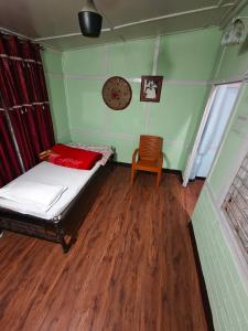 a small bedroom with a bed and a chair at Hemalata Heritage Home in Guwahati