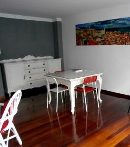 a white table and four chairs in a room at A Barca de Pedra in Padrón