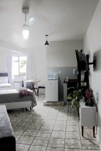 a bedroom with a bed and a table and a desk at Loft Recanto Dos Cavalheiros! Com Ar Condicionado! in Macaé