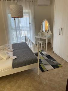 a bedroom with a bed with a mirror and a table at Ioannis Apartment in Syvota