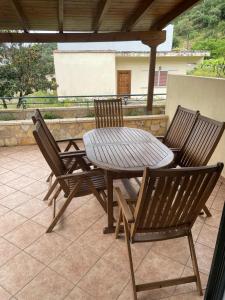 a wooden table and chairs on a patio at Ioannis Apartment in Syvota