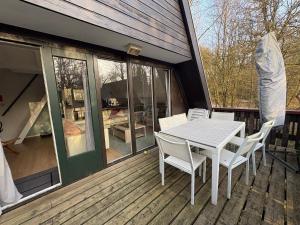 a table and chairs on the deck of a house at Sequoia Duo 2 chalets voisins, familles,amis,détente in Durbuy