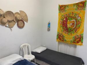a room with a bed and a curtain and a chair at Borba Beach House in Recife