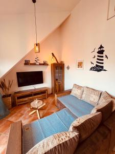 a living room with a couch and a flat screen tv at Maisonette am See in Seedorf