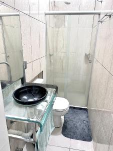 a bathroom with a toilet and a glass shower at Edifício AES Brasil in Cairu