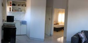 a white kitchen with a room with a bed at Elclassico Villa in Nyanda