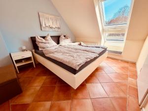 a bedroom with a bed in a room with two windows at Maisonette am See in Seedorf