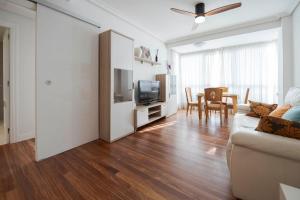 a living room with a couch and a television and a table at Bañeru Zarautz Centro - Sol, playa y confort, todo a un paso in Zarautz