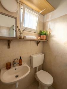 a bathroom with a toilet and a sink and a mirror at White Emerald in Haifa