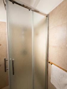 a shower stall with a glass door in a bathroom at White Emerald in Haifa