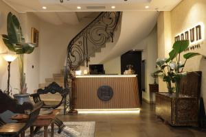 a lobby with a staircase and a table and chairs at Monun Boutique Hotel in Tirana