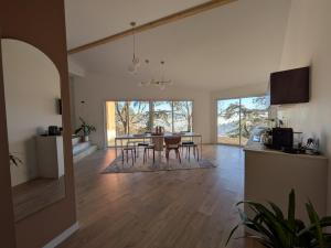a kitchen and living room with a table and chairs at Maison Terracotta in Saint-Priest-en-Jarez