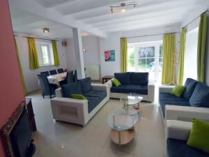 sala de estar con sofás, TV y mesa en House adjoining mansion for a pleasant stay in the region of Chimay, en Plagneau