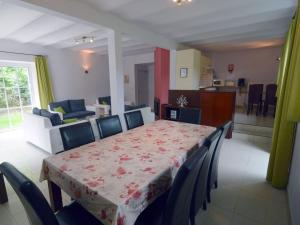 comedor con mesa y sillas y cocina en House adjoining mansion for a pleasant stay in the region of Chimay, en Plagneau