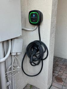 a cord hooked up to a wall with a plug at Miami Stay - Pool, Parking, & Affordable Transportation in Tamiami