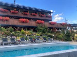 a hotel with chairs and a swimming pool at Apartamenty Black Lion in Pcim