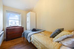 a bedroom with a bed and a dresser and a window at The Retreat with Free Parking in Ambleside