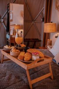 a table with a plate of food and a glass of wine at Goat Lodge DOMO BALI in Ibiúna +37 photos