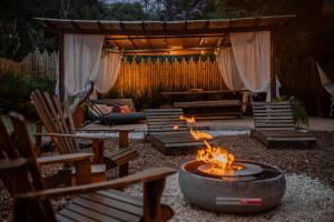 a fire pit in a backyard with chairs and a gazebo at Goat Lodge DOMO BALI in Ibiúna