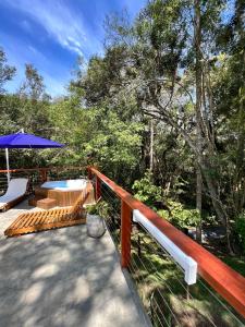 a wooden deck with a table and an umbrella at Goat Lodge DOMO BALI in Ibiúna