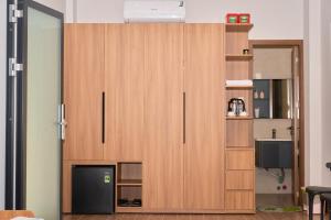 a large wooden cabinet in a room with a television at ArionHotel in Ninh Hải
