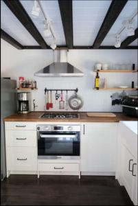 a kitchen with white cabinets and a stove top oven at Lilys Little Lodge in Blairmore