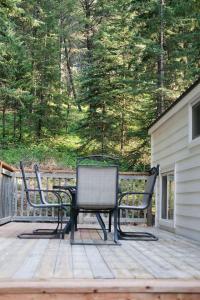 two chairs and a table on a deck at Lilys Little Lodge in Blairmore