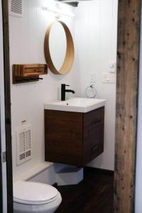a bathroom with a sink and a toilet and a mirror at Lilys Little Lodge in Blairmore +18 photos