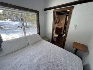a bedroom with a bed and a large window at Lilys Little Lodge in Blairmore
