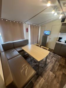a room with a couch and a table and a kitchen at Les mobil homes de NOLY TV CLIM 6places 1 place adulte offerte pour la réserve africaine sigean in Port-la-Nouvelle