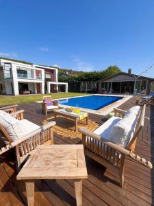 a deck with two benches and a table and a pool at Villa Meg with Private Pool, Sauna Jacuzzi in Kadıköy