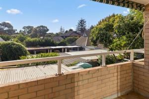 a balcony with a brick wall and a wooden deck at Georgies Simple Base in Mosman Park in Mosman Park