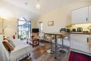 a room with a bed and a kitchen with a table at The Retreat with Free Parking in Ambleside