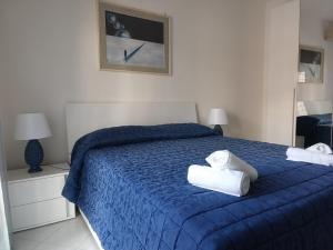 a bedroom with a blue bed with towels on it at Sole e relax da Michelle in Anzio +18 photos