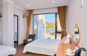 a bedroom with a bed and a large window at ArionHotel in Ninh Hải
