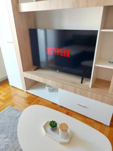 a living room with a television in a cabinet at Apartman Stella Banja Luka in Krndija