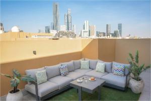 a couch on a rooftop with a view of a city at LIV by Yamama - KAFD in Riyadh