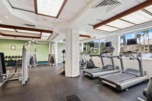 a gym with several treadmills and elliptical machines at Pristine Hotel Room at Popular Resort in Lihue