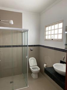 a bathroom with a toilet and a sink at Espaço Guga in Sorocaba +5 photos