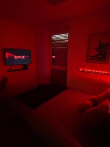 a red room with a bed and a television at Amour x Paris x Netflix x Wheel chair Access in Ivry-sur-Seine