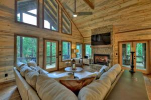 a living room with a couch and a fireplace at Altitude Adjustment- Luxury 3BR Cabin w/ Outdoor Living Area & Hot Tub in Epworth