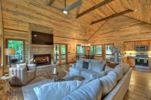 a living room with a large couch and a fireplace at Altitude Adjustment- Luxury 3BR Cabin w/ Outdoor Living Area & Hot Tub in Epworth
