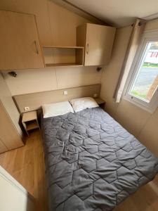 a large bed in a small room with a window at Les mobil homes de NOLY TV CLIM 6places 1 place adulte offerte pour la réserve africaine sigean in Port-la-Nouvelle +43 photos