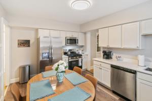 a kitchen with a table with a vase of flowers on it at USS Alexandria in Highwood