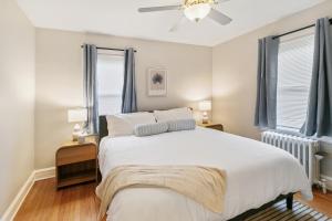 a bedroom with a large white bed and two windows at USS Alexandria in Highwood